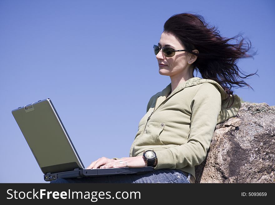 Woman with laptop on blue sky background