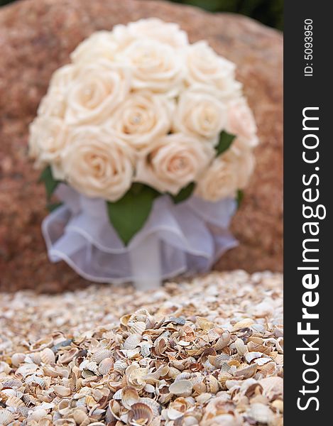Bride bouquet out of focus over seashells
