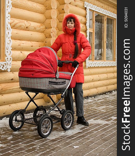 Winter Girl in Red Hood with Baby Carriage Outdoors