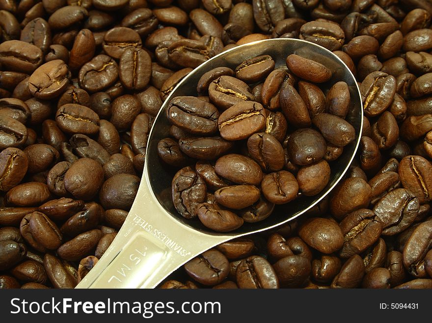 Measuring spoon full of coffee beans