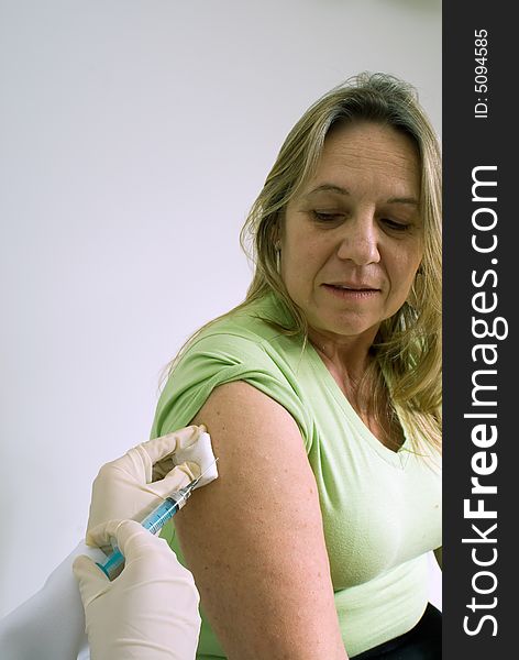 An isolated shot of a doctor/nurse about to give a female patient a shot in the arm. An isolated shot of a doctor/nurse about to give a female patient a shot in the arm.