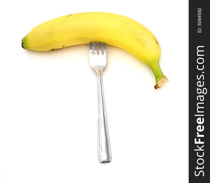 Ripe banana with a silver fork stick on it. Ripe banana with a silver fork stick on it