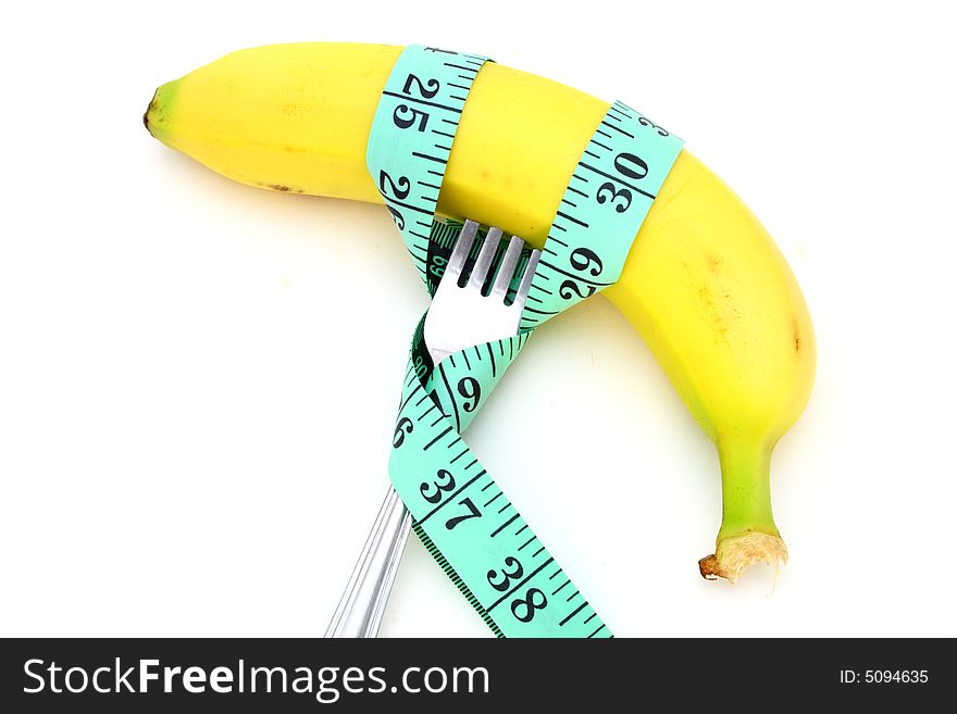 Green tape measure wrapped around a banana and a fork. Green tape measure wrapped around a banana and a fork