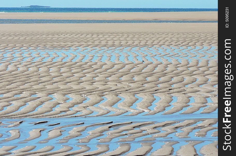 This shows a deeply sculptured beach at Hunter Creek. Water fills the low points to create an intricate pattern across the sand flats at low tide. This shows a deeply sculptured beach at Hunter Creek. Water fills the low points to create an intricate pattern across the sand flats at low tide.