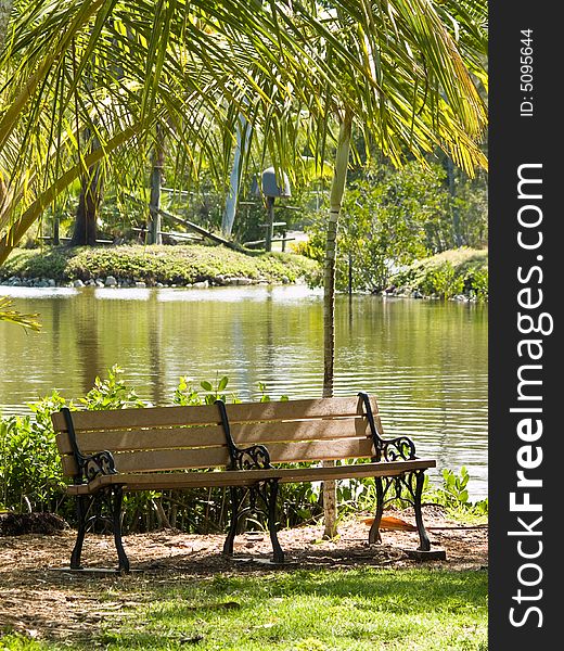 Empty bench by a lake on a summer day. Empty bench by a lake on a summer day.