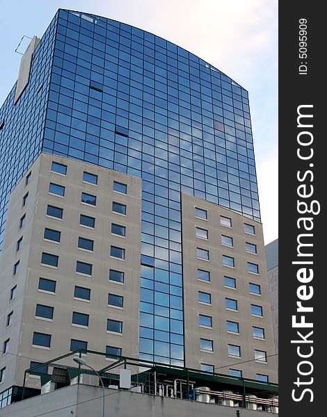 Glass building against a bright blue sky with cloud reflections. Glass building against a bright blue sky with cloud reflections