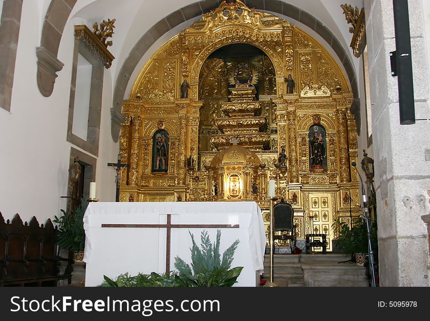 Portuguese church main altar with golden decoration behind
