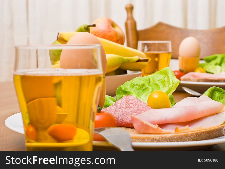 Table served with snacks. Fruits, vegetables, bread, egg, ham etc. Table served with snacks. Fruits, vegetables, bread, egg, ham etc.