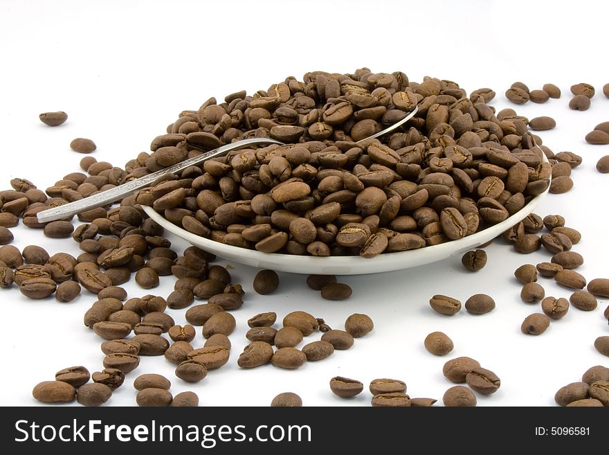 Saucer with coffee beans isolated