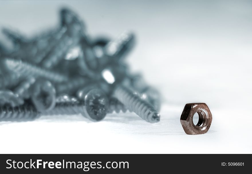 A heap of screws with a non-fitting screw nut. A heap of screws with a non-fitting screw nut