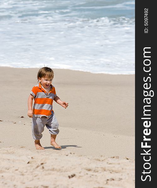Young happy boy walking on sandy beach. Young happy boy walking on sandy beach