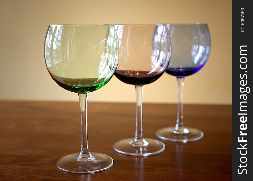 Different colored wine glasses with a simple background