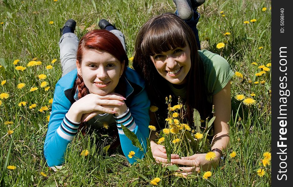 Two beautiful girls laying on meadow