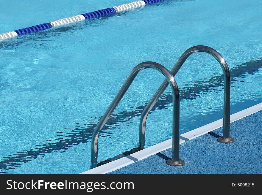 Metal chromeplated ladder in open pool. Metal chromeplated ladder in open pool