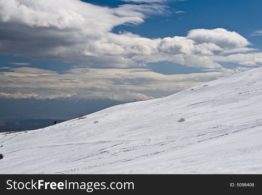 Snowy white mountain slope with blue sky. Snowy white mountain slope with blue sky