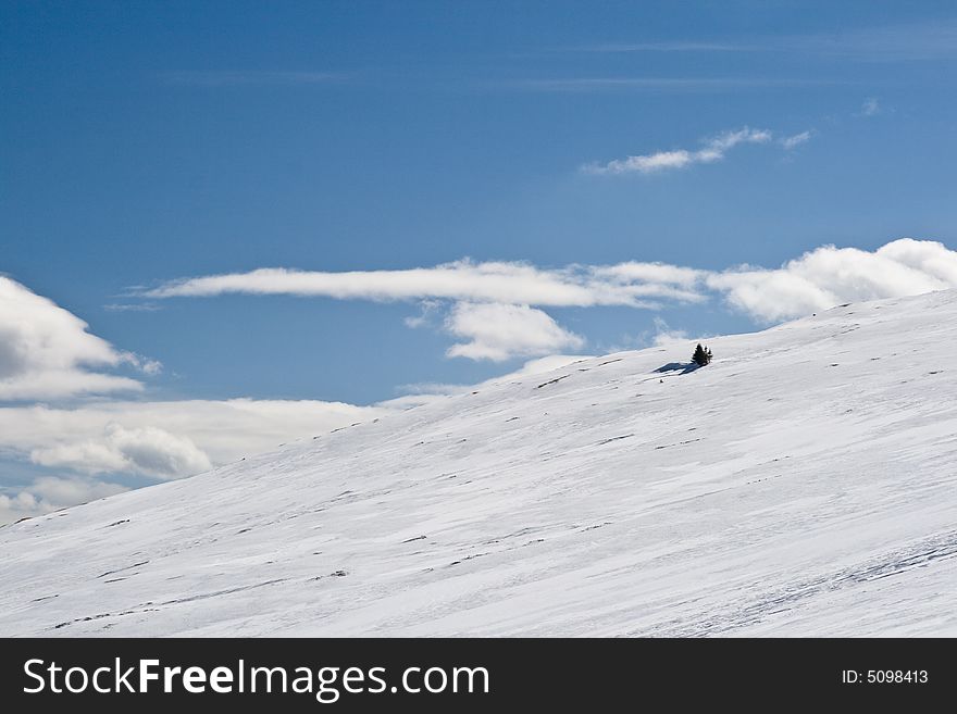 Snowy white mountain slope with blue sky. Snowy white mountain slope with blue sky