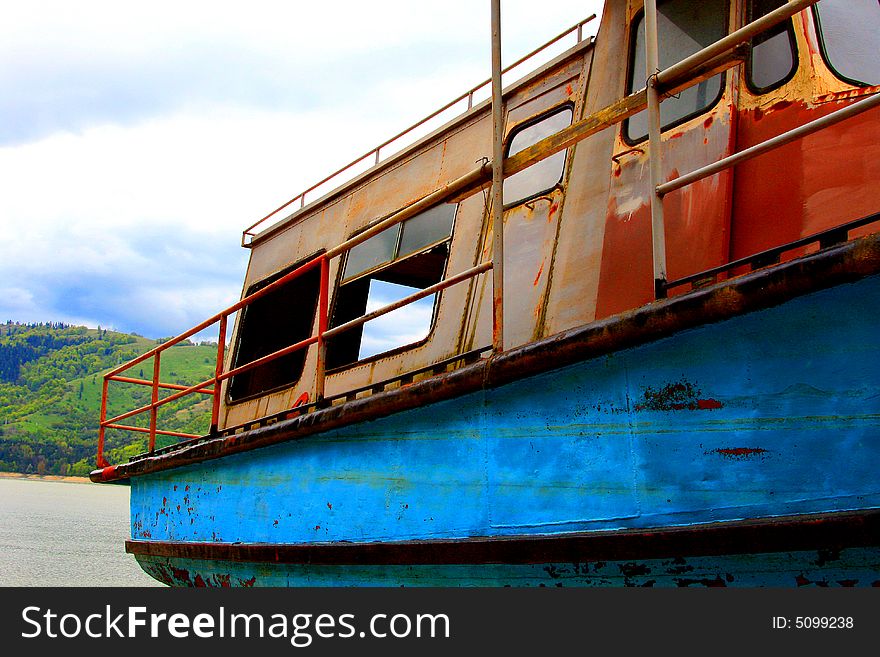 Abandoned boat near a mountain lake