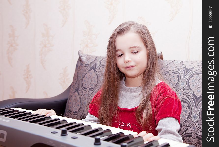 Little Girl Playing On A Synthesizer