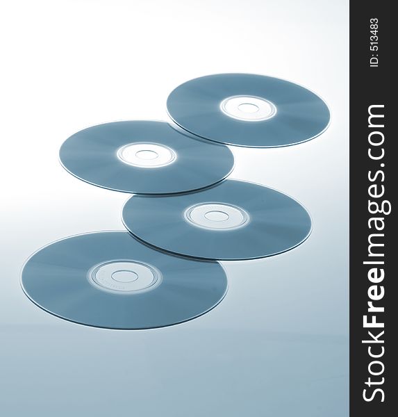 Stack of four blank cds on a blue background