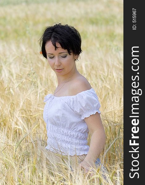 Natural beautiful girl in the field of golden wheat