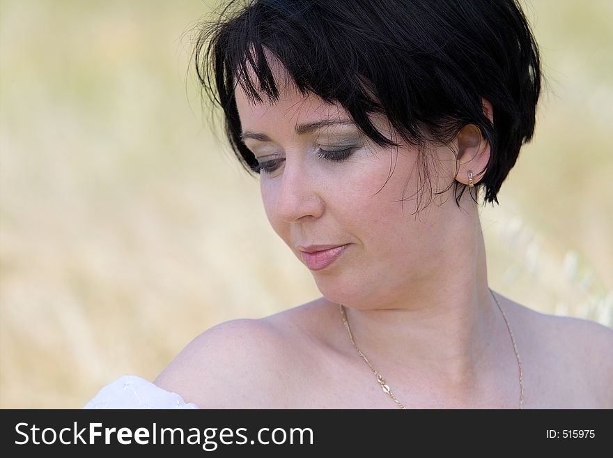 Natural beautiful girl in the field of golden wheat