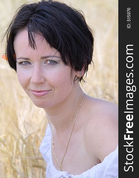 Natural beautiful girl in the field of golden wheat