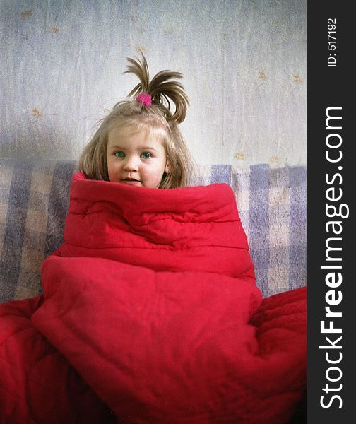 Portrait of a little girl wraped up in the red blanket. Portrait of a little girl wraped up in the red blanket