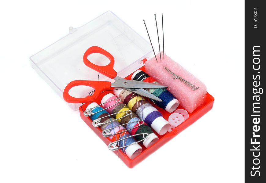 Miniature sewing kit with colorful thread, scissors, safety pins, straight pins, needles and buttons.