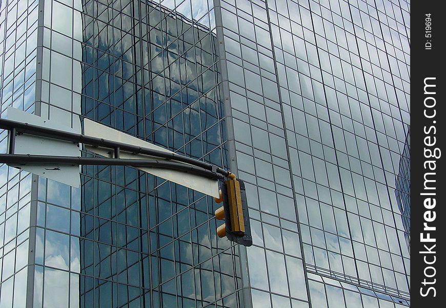 A skyscraper and the back of a traffic light. A skyscraper and the back of a traffic light