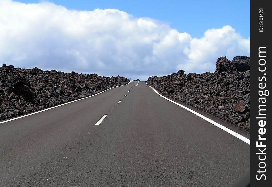 This modern road is located between lava rocks of the volcanic island of Lanzarote. This modern road is located between lava rocks of the volcanic island of Lanzarote