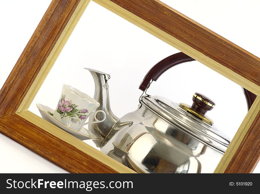 Teapot and cup within the framework against the white background. Teapot and cup within the framework against the white background