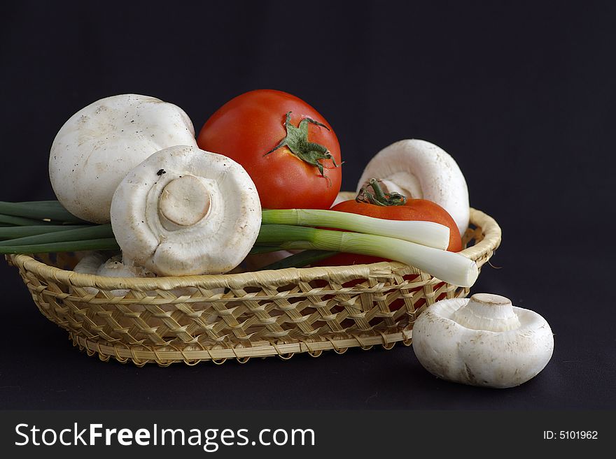 Several agarics, tomatoes and onion against the black background by the closeup. Several agarics, tomatoes and onion against the black background by the closeup