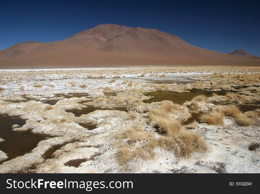 Mountain range with feature land full of small puddles of a drought lake. Altiplano. Bolivia. Mountain range with feature land full of small puddles of a drought lake. Altiplano. Bolivia.
