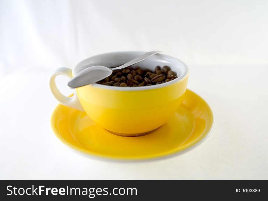 Yellow cup of coffee seeds