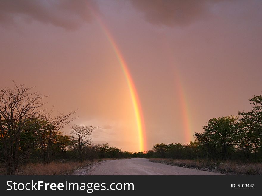 Dramatic stormy sky with rainbow over the Etosha national park. Namibia. Dramatic stormy sky with rainbow over the Etosha national park. Namibia.