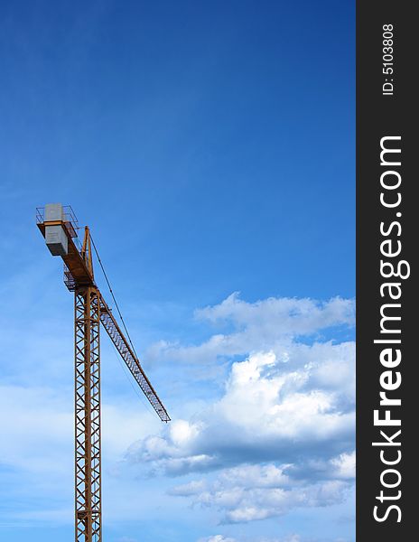 Construction jack-up crane with blue sky and clouds