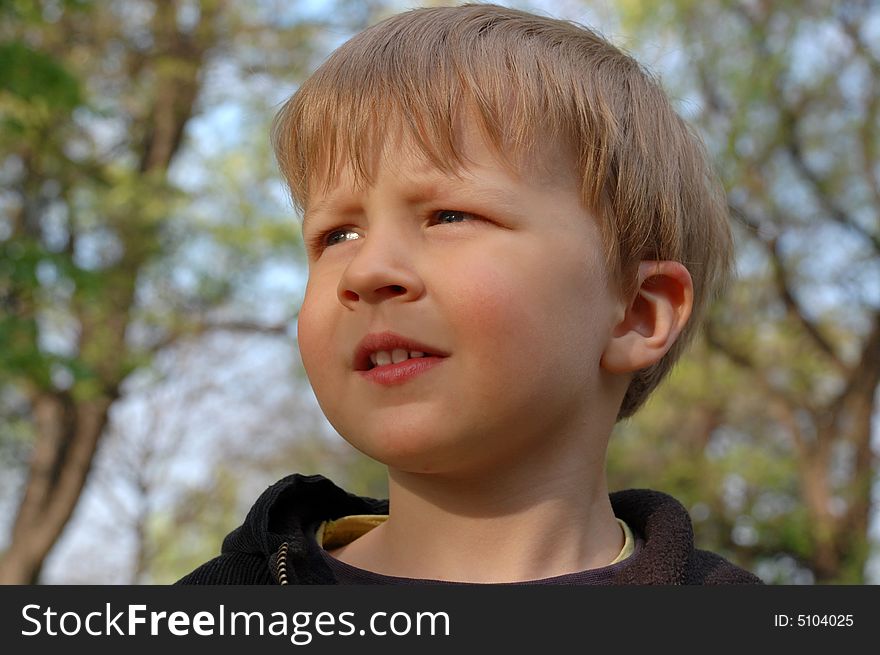 Happy pretty little boy on tree background