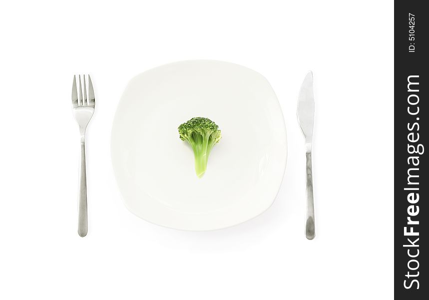 Broccoli on a dinner plate with fork and knife