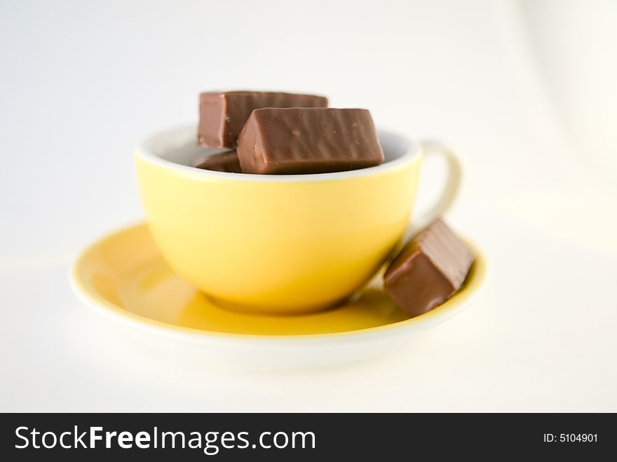 Sweet, tasty chocolate bars in nice yellow cup, metaphore of hot chocolate. Sweet, tasty chocolate bars in nice yellow cup, metaphore of hot chocolate