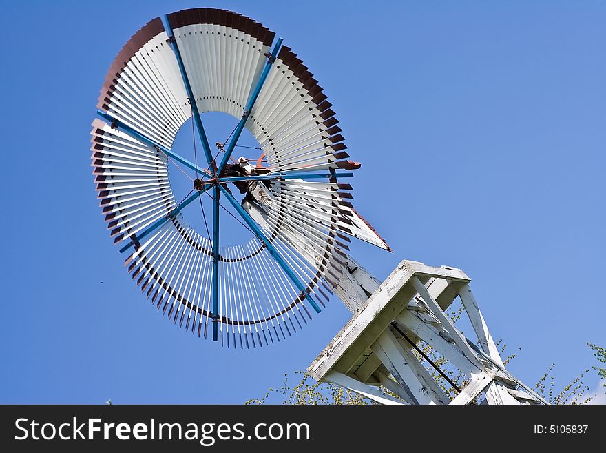 Old windmill against a blue sky nice green background image. Old windmill against a blue sky nice green background image