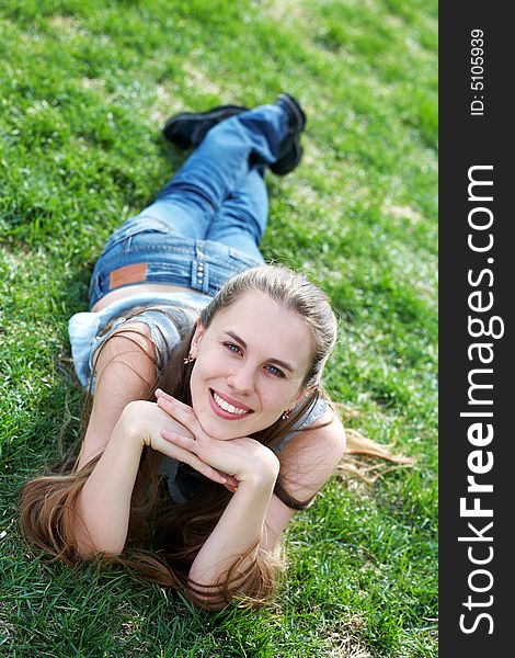 Smiling girl lying an green grass at sunshine. Smiling girl lying an green grass at sunshine