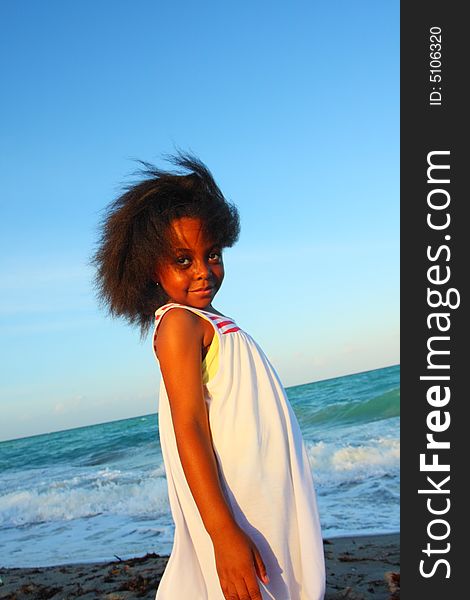 Young Black Child on the beach smiling and watching the sunset. Young Black Child on the beach smiling and watching the sunset.