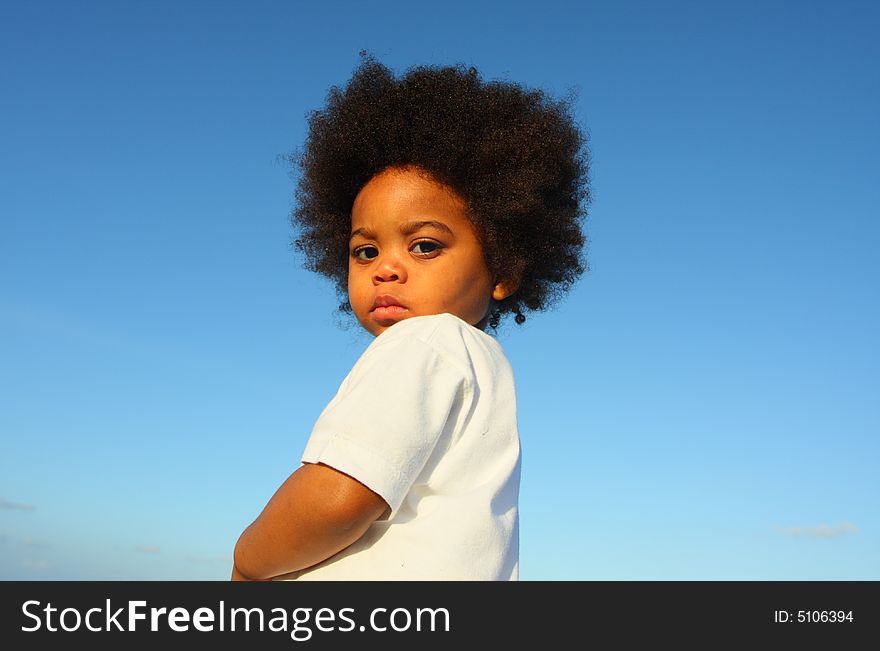 Cute little child with a blue sky background. Cute little child with a blue sky background.