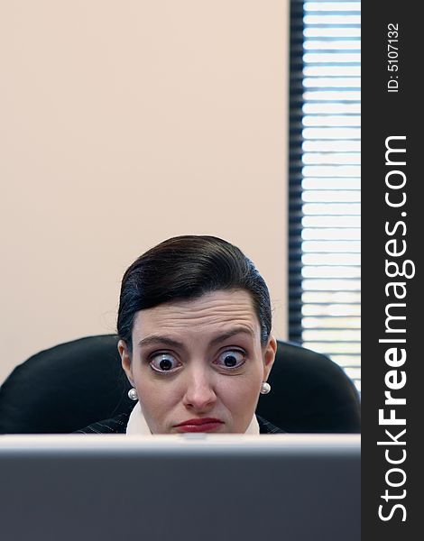 Businesswoman sitting at her desk behind her laptop. Businesswoman sitting at her desk behind her laptop