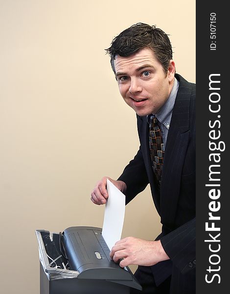 Caucasian businessman caught off guard while shredding documents at his desk. Caucasian businessman caught off guard while shredding documents at his desk