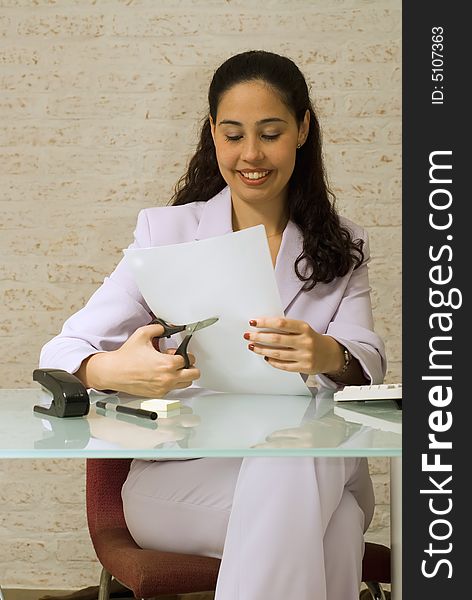 An isolated shot of a businesswoman cutting papers.