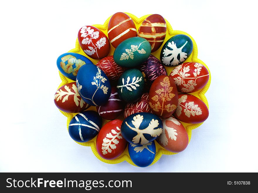 Multicolored easter egg on big yellow plate isolate over white. Multicolored easter egg on big yellow plate isolate over white