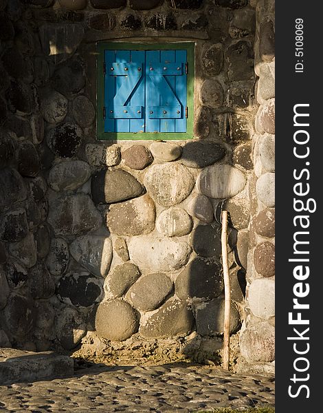 Shadow play on a blue window and stone wall