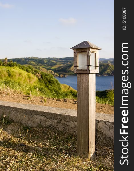 A wooden light post on a grassy patch