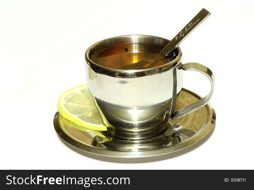 Metallic cup of tea with lemon on white background isolated